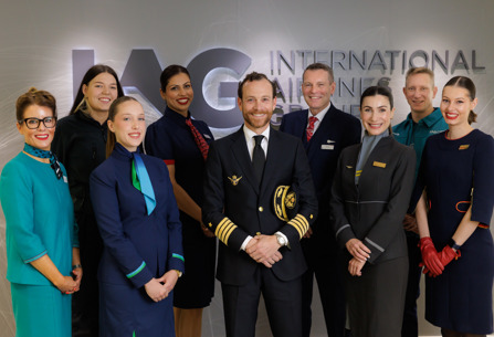 Staff from IAG airlines and IAG Cargo posing in front of logo.