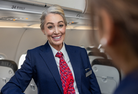 Member of British Airways cabin crew talking to person on board