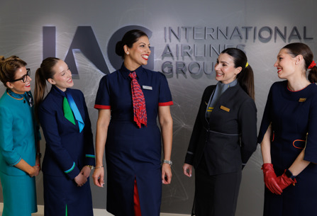 Cabin crew from IAG airlines posing in front of IAG logo