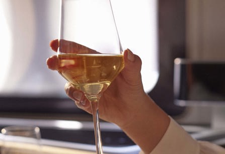 Customer holding glass of wine in British Airways first class
