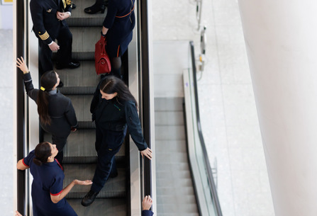 IAG businesses' staff members on escalator at Heathrow